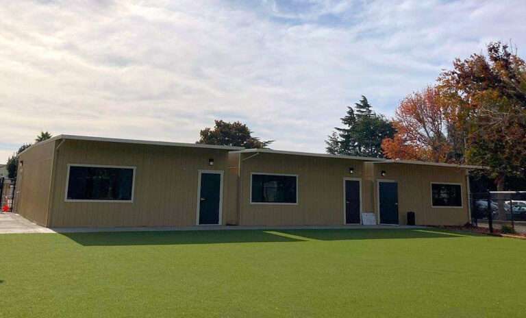 A row of single story, tan modular buildings.